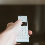 Télécommande de télévision dirigée vers un écran allumé