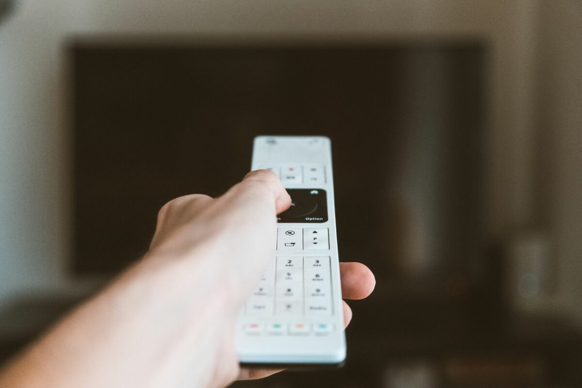 Télécommande de télévision dirigée vers un écran allumé