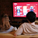 Deux personnes regardant une série en streaming sur un grand écran