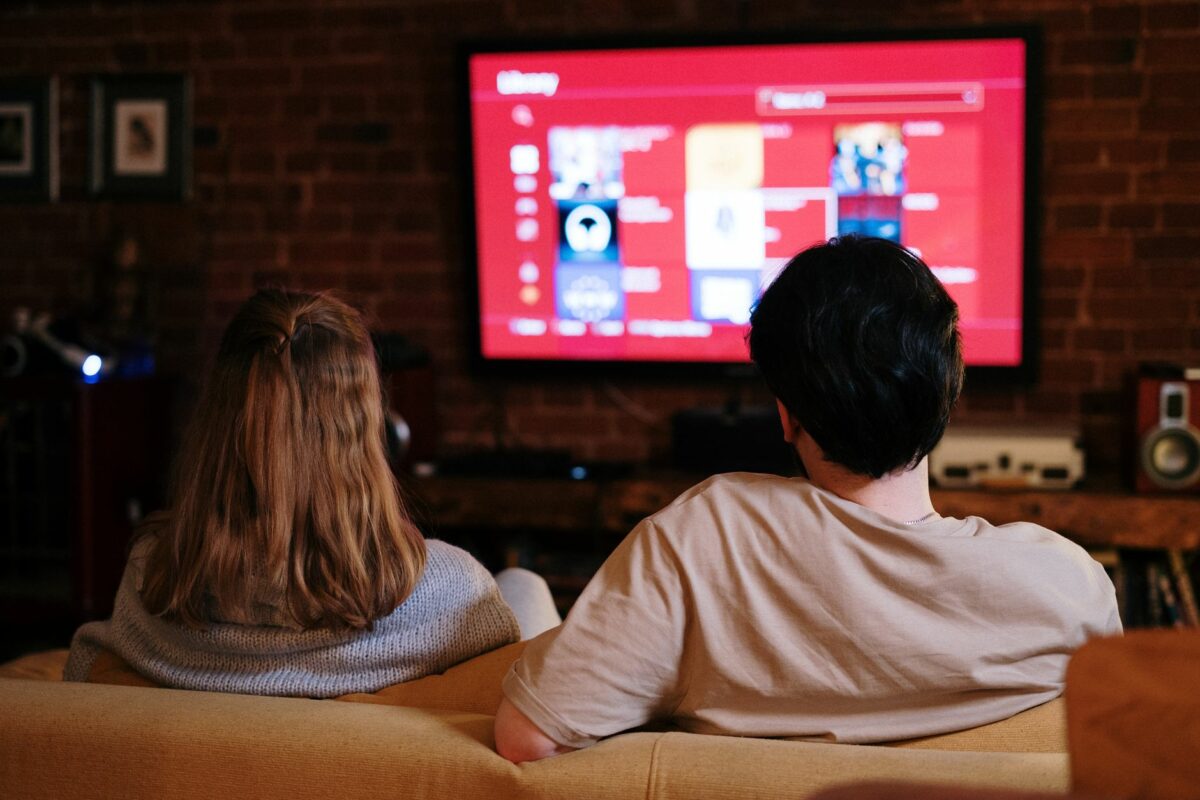 Deux personnes regardant une série en streaming sur un grand écran