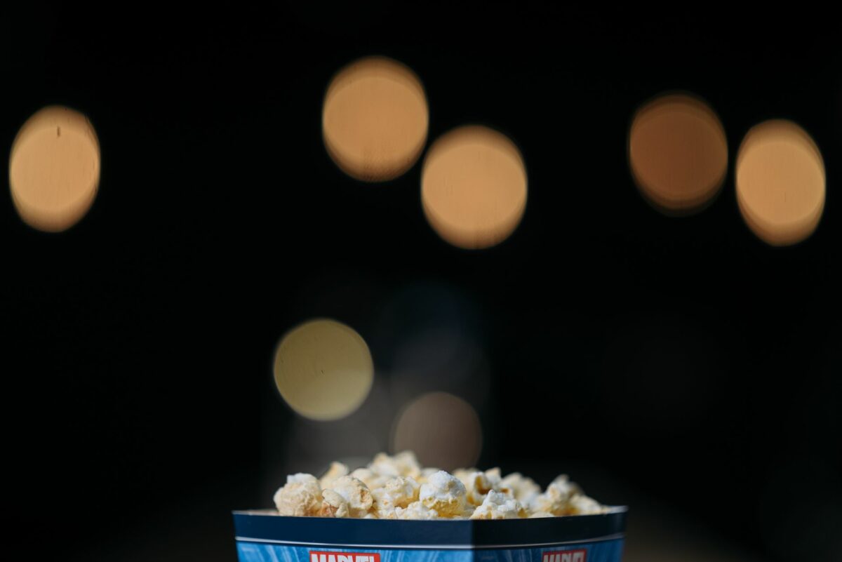 Seau de popcorn devant un écran de cinéma flou
