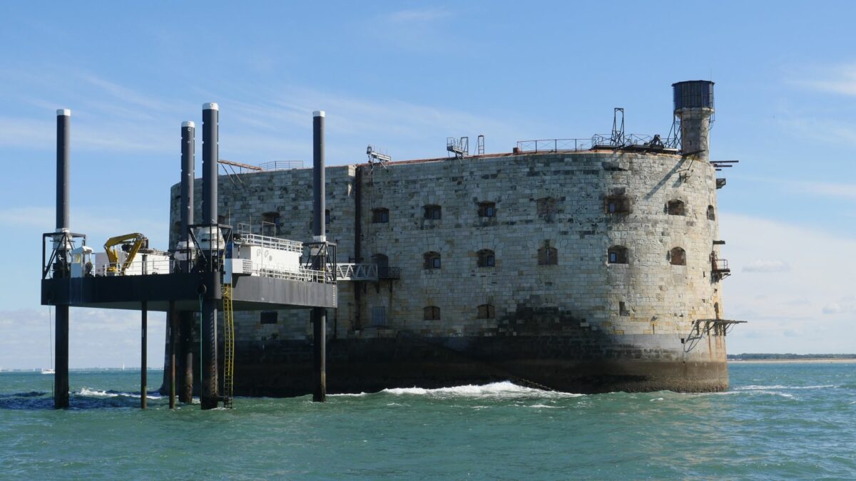 Historical Fort Boyard standing in the sea with a bright blue sky background.
